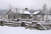 Early snow on log house
